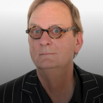 head shot of peter goers - black top, hair receding, and glasses with a round frame